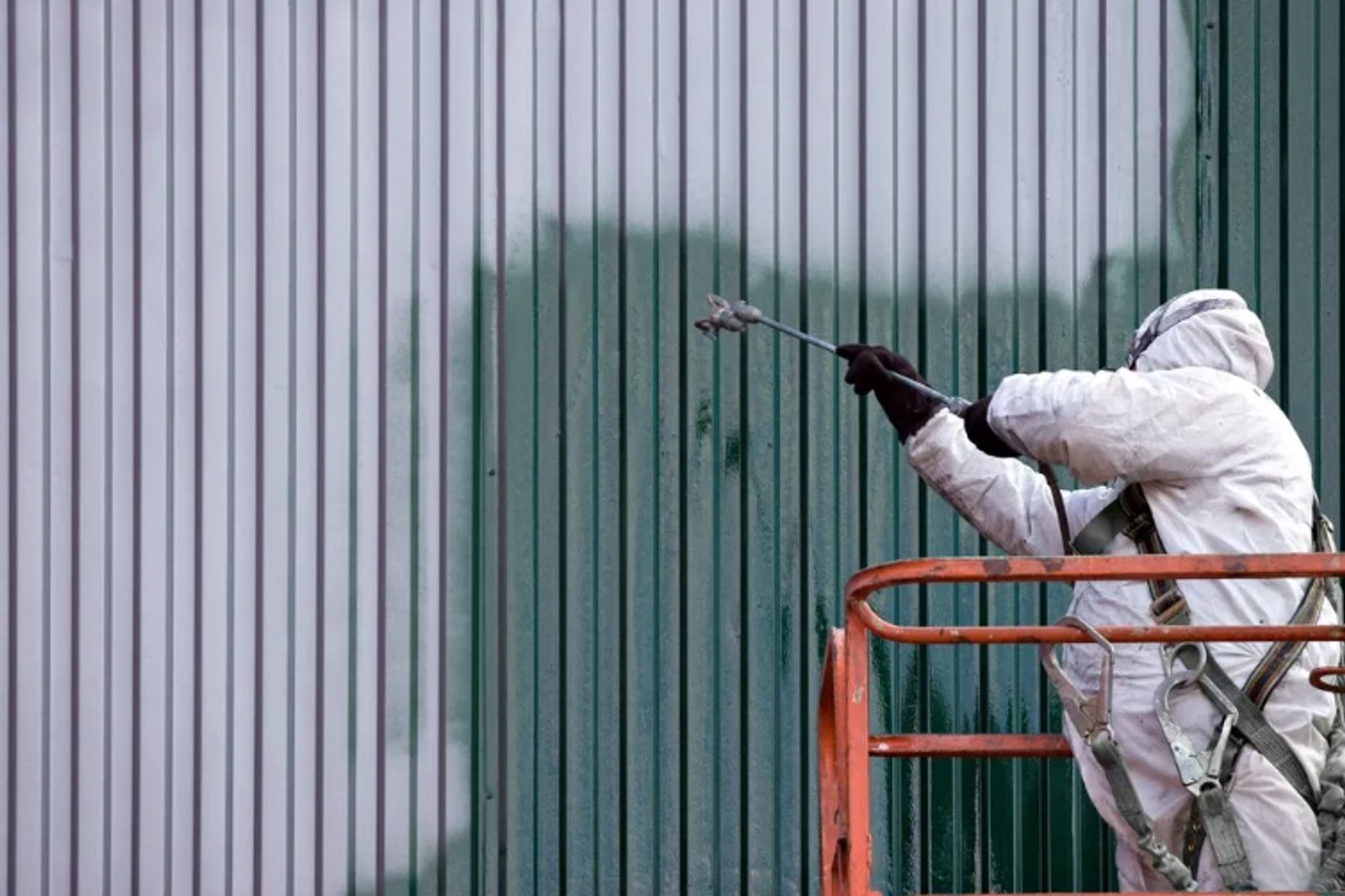 Worker applying a protective coating to an industrial surface